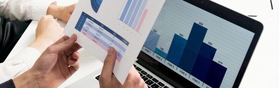 Business professionals discussing data charts and graphs in a modern office setting.